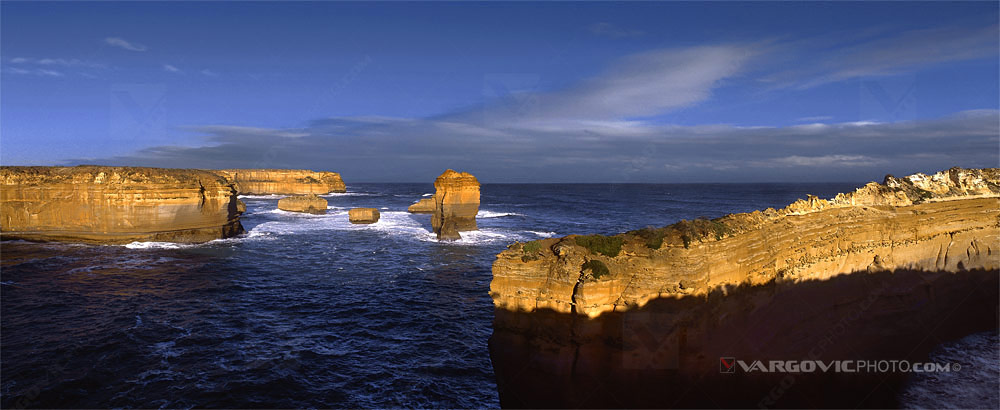 Rocks under golden sun in Australian Marine National Park Twelve Apostles in the state of Victoria